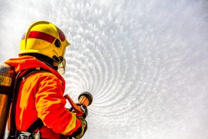 firefighter using extinguisher water from hose fire fighting 300x200